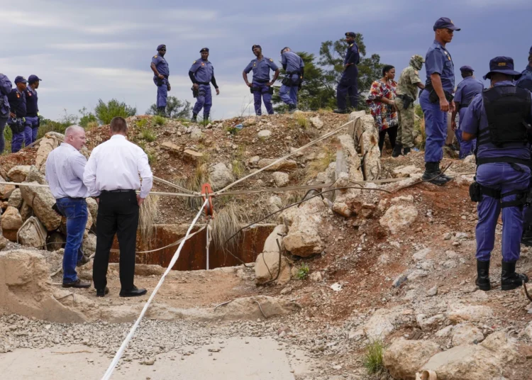 Trapped Miners Rescued from South African Gold Mine 1 South African police at the opening of the mine with trapped illegal miners