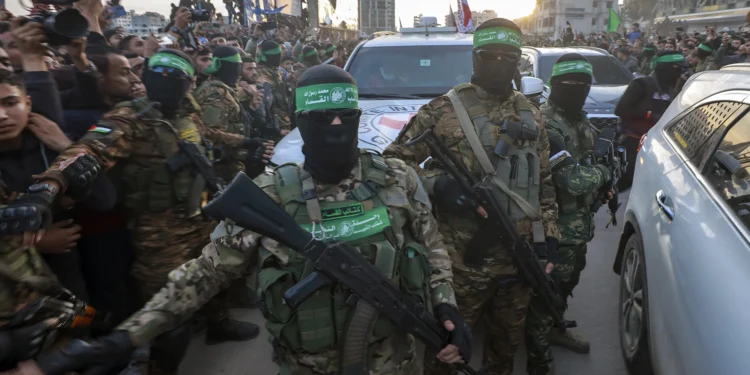 Hamas fighters escort a Red Cross vehicle to collect Israeli hostages released after a ceasefire agreement between Israel and Hamas took effect, in Gaza City Sunday, Jan. 19, 2025.