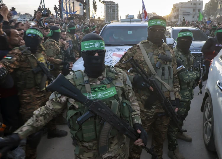 Hamas fighters escort a Red Cross vehicle to collect Israeli hostages released after a ceasefire agreement between Israel and Hamas took effect, in Gaza City Sunday, Jan. 19, 2025.