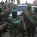 Hamas fighters escort a Red Cross vehicle to collect Israeli hostages released after a ceasefire agreement between Israel and Hamas took effect, in Gaza City Sunday, Jan. 19, 2025.