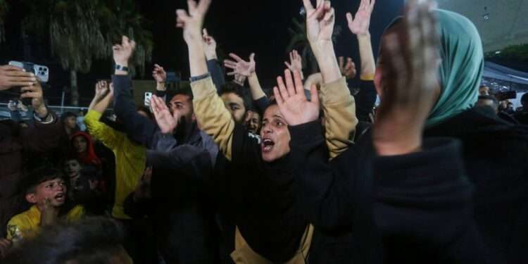 Palestinians in the garden of Al-Aqsa Martyrs Hospital in Gaza gather to celebrate the ceasefire deal.