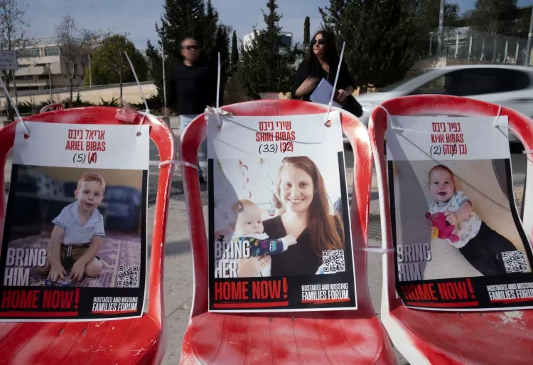 Posters of Shiri Bibas, centre, and her sons Ariel, left, and Kfir.