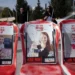 Posters of Shiri Bibas, centre, and her sons Ariel, left, and Kfir.