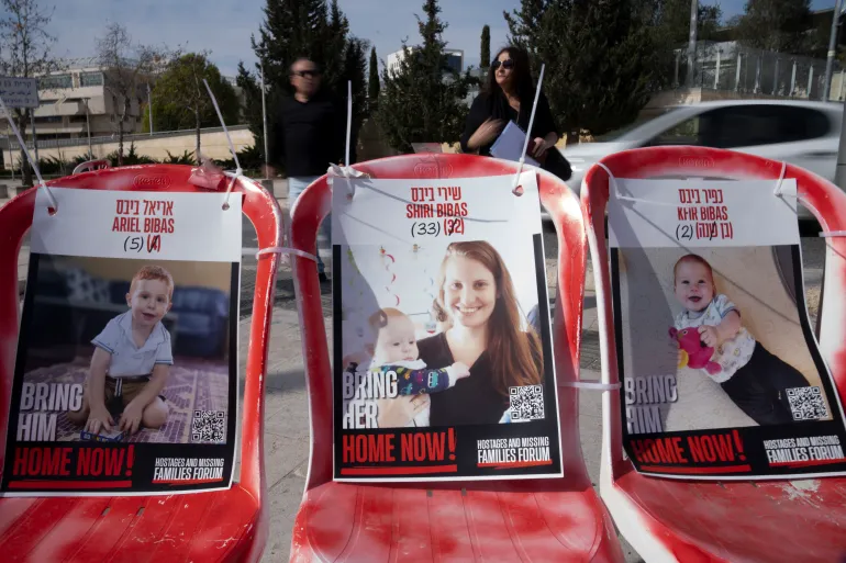 Posters of Shiri Bibas, centre, and her sons Ariel, left, and Kfir.