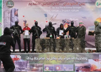 Israeli captives Tal Shoham, second from left, and Avera Mengistu, fourth from right, are flanked by Hamas fighters as they stand on a stage during their release in Rafah, Gaza.