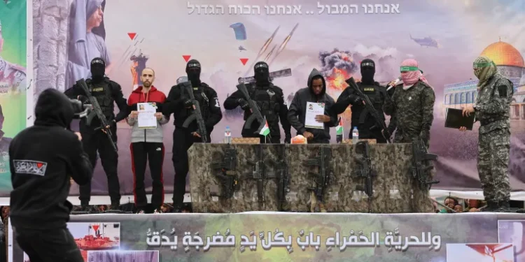 Israeli captives Tal Shoham, second from left, and Avera Mengistu, fourth from right, are flanked by Hamas fighters as they stand on a stage during their release in Rafah, Gaza.