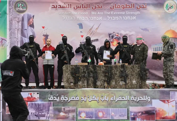 Hamas Releases Captives In Final Swap Under Ceasefire’s First Phase 1 Israeli captives Tal Shoham, second from left, and Avera Mengistu, fourth from right, are flanked by Hamas fighters as they stand on a stage during their release in Rafah, Gaza.