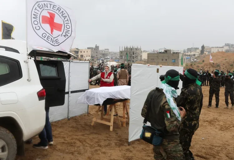 A member of the Red Cross stands near a coffin during the handover of the bodies of four Israeli hostages.