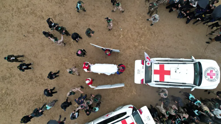 A drone view shows members of the Red Cross receiving a coffin as Hamas hands over the remains of Israeli captives on Thursday in Gaza as part of ceasefire deal.