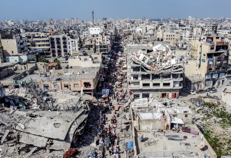 Arab Leaders Set To Meet To Counter Trump’s Gaza Plan 1 A drone view shows Palestinians walking at a street market near buildings damaged and destroyed during the Israeli offensive, amid the Israel-Hamas ceasefire in Gaza City, February 17, 2025.