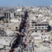 A drone view shows Palestinians walking at a street market near buildings damaged and destroyed during the Israeli offensive, amid the Israel-Hamas ceasefire in Gaza City, February 17, 2025.