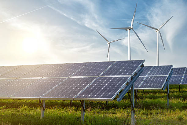 solar panels and wind generators under blue sky on sunset