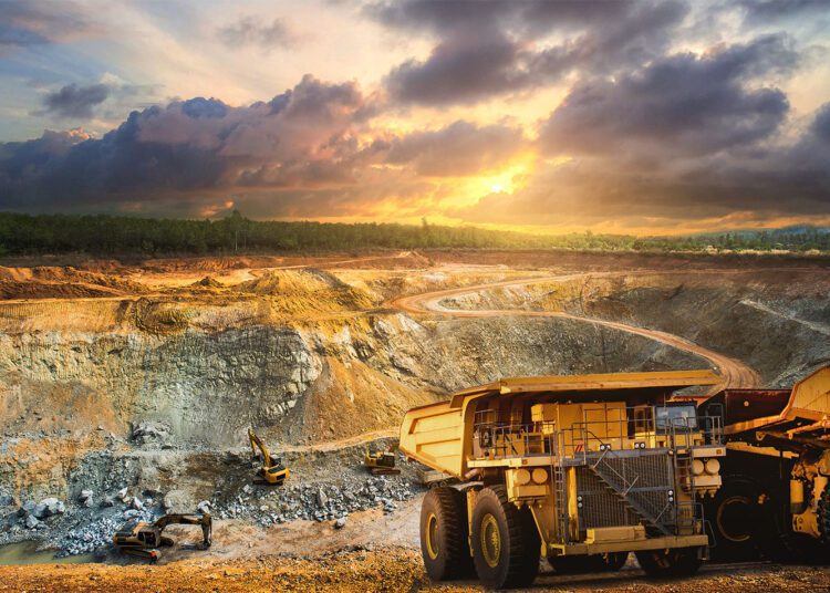 AngloGold, Gold Fields Suspend Iduapriem Merger Talks 1 Yellow dump truck loading minerals gold at mining quarry.