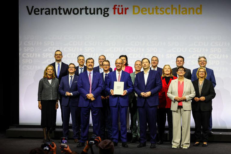 Germany’s Mainstream Parties Sign Coalition Deal 3 Incoming German Chancellor and leader of the Christian Democratic Union (CDU) Friedrich Merz holds the coalition government agreement between CDU, CSU and SPD, next to Christian Social Union (CSU) leader and Bavarian Premier Markus Soeder and Designated German Vice Chancellor and Designated Finance Minister Lars Klingbeil, at the Gasometer in Berlin, Germany May 5, 2025.