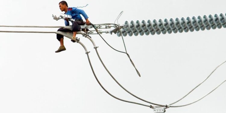 Copper Emerges As World’s Next Strategic Prize 1 A worker in the Philippines installs a new electric cable atop a pylon.
