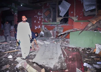 Local residents examine a building damaged by an Indian missile attack near Muzaffarabad amid Danger Of Further Escalation