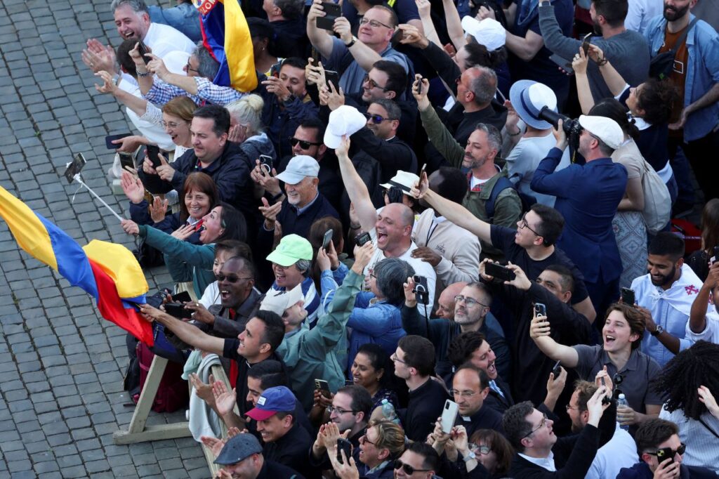 People in St. Peter's Square react to white smoke from the chimney on the Sistine Chapel. 