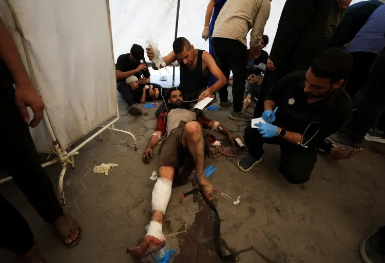 People being attended to following the Israeli attack on The Church of the Holy Family