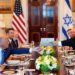 Israel's Prime Minister Benjamin Netanyahu hands President Donald Trump a folder during a meeting in the Blue Room of the White House, Monday,