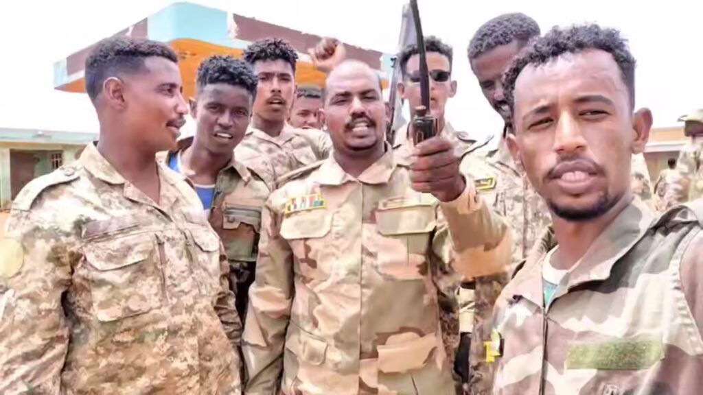 commander of the Sudan Shield Forces gestures as he stands with his fighters near the site of a deadly drone attack in Tumbul Sudan August 13 2025