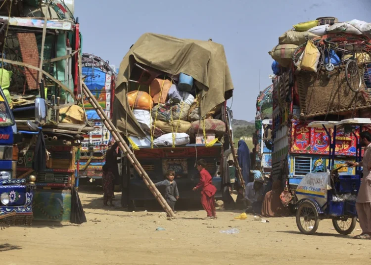 Afghan refugee children play next to trucks loaded with their family’s belongings as they wait to return Afghanistan along a highway in Landi Kotal, Pakistan, April 9, 2025.