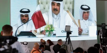 Journalists watch on a screen at the media center as Sheikh Tamim bin Hamad Al Thani, the emir of Qatar, speaks