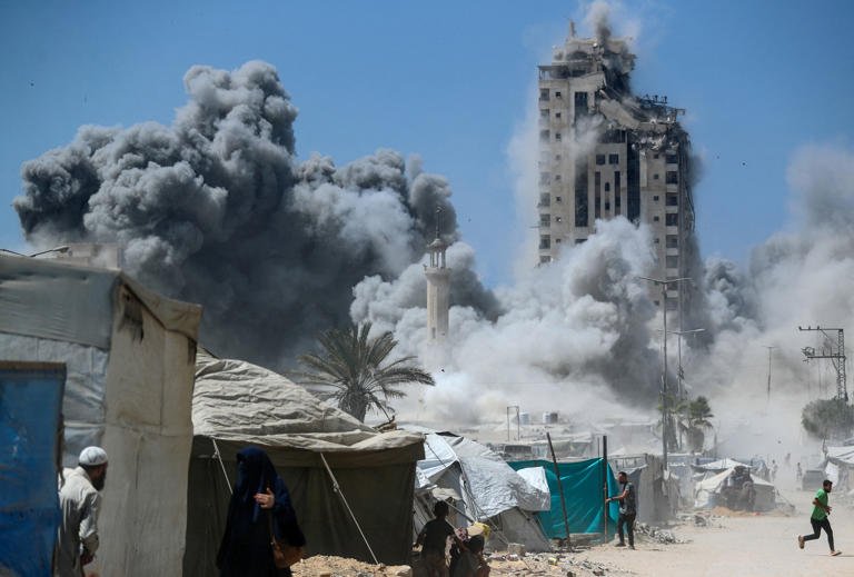 Israel Strikes High-Rise Building In Gaza City Offensive 1 A man runs as smoke rises after a building is hit by an Israeli air strike, in Gaza City on Friday, September 5.