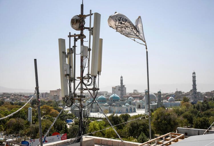 Communications Blackout Hits Afghanistan In Latest Taliban Crackdown 1 A Taliban flag flutters near telecom equipment installed over a rooftop providing internet services overlooking Hazrat-e-Ali Shrine, or Blue Mosque, in Mazar-i-Sharif on September 16, 2025, as the Taliban administration banned fibre-optic internet in Balkh province.