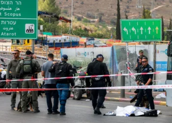 Israeli forces gather by a body next to a bus at Ramot Junction in occupied East Jerusalem on September 8, 2025.