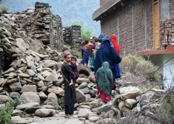Locals in Mazar Dara in Kunar province walk by a house destroyed in an earthquake that killed hundreds of people and destroyed villages in eastern Afghanistan.