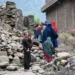 Locals in Mazar Dara in Kunar province walk by a house destroyed in an earthquake that killed hundreds of people and destroyed villages in eastern Afghanistan.
