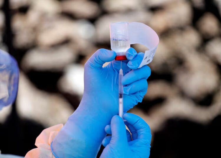 A health worker fills a syringe with Ebola vaccine before injecting it to a patient, in Goma, Democratic Republic of Congo