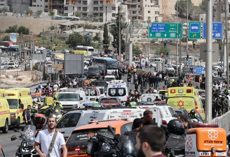 Israeli forces gather by a body next to a bus at Ramot Junction in occupied East Jerusalem on September 8, 2025.
