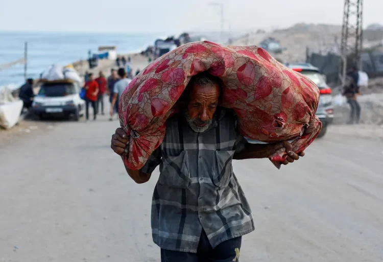 Israel Intensifies Efforts To Displace Palestinians 1 A displaced Palestinian man, fleeing northern Gaza due to Israeli attacks, carries his belongings as he moves southward after Israeli forces ordered residents of Gaza City to evacuate.