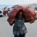 A displaced Palestinian man, fleeing northern Gaza due to Israeli attacks, carries his belongings as he moves southward after Israeli forces ordered residents of Gaza City to evacuate.