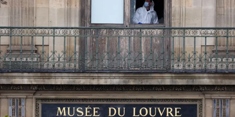 A member of a forensic team inspects a window believed to have been used in a robbery at the Louvre Museum in Paris, France, on October 19, 2025.