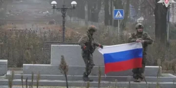 A soldier holds a Russian flag in Pokrovsk