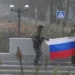 A soldier holds a Russian flag in Pokrovsk