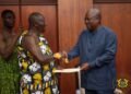 Asantehene Otumfuo Osei Tutu II (L) handing over the Mediation Report to President John Dramani Mahama (R)