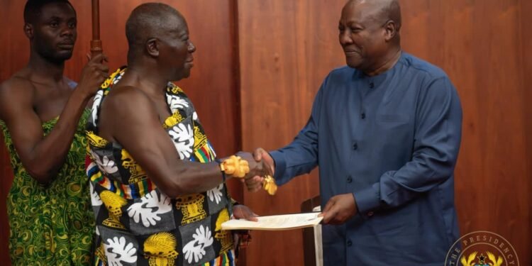 Asantehene Otumfuo Osei Tutu II (L) handing over the Mediation Report to President John Dramani Mahama (R)