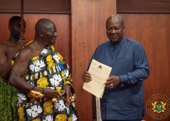 Asantehene Otumfuo Osei Tutu II (L) handing over the Mediation Report to President John Dramani Mahama (R)