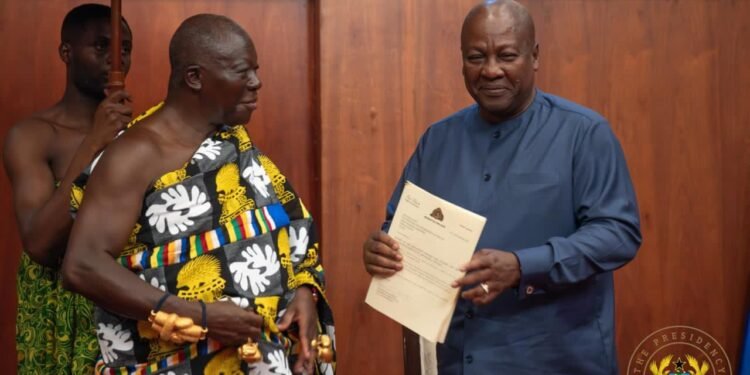 Asantehene Otumfuo Osei Tutu II (L) handing over the Mediation Report to President John Dramani Mahama (R)