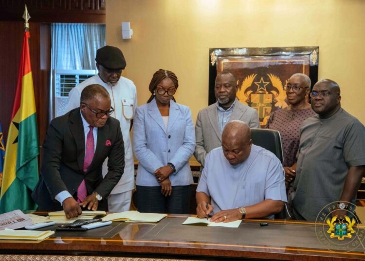 President John Dramani Mahama signing the five Bills as passed by Parliament