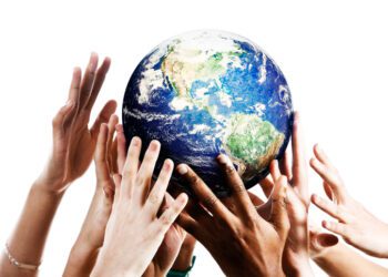 Many mixed hands reaching up to grab a piece of Mother Earth.