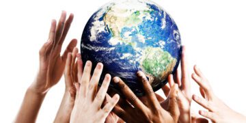Many mixed hands reaching up to grab a piece of Mother Earth.