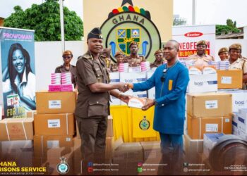 A Ghana Prison Service official receiving the donations from Ernest Chemist
