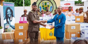 A Ghana Prison Service official receiving the donations from Ernest Chemist