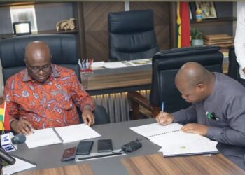 MoFA partners FarmMate To Boost Tomato Production, Limit Import 4 Minister of Food and Agriculture, Eric Opoku signing the MoU with Sena Amevor, Ceo of FarmMate LTD