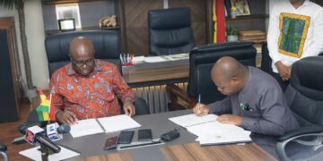 Minister of Food and Agriculture, Eric Opoku signing the MoU with Sena Amevor, Ceo of FarmMate LTD