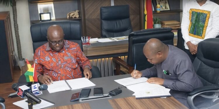 Minister of Food and Agriculture, Eric Opoku signing the MoU with Sena Amevor, Ceo of FarmMate LTD